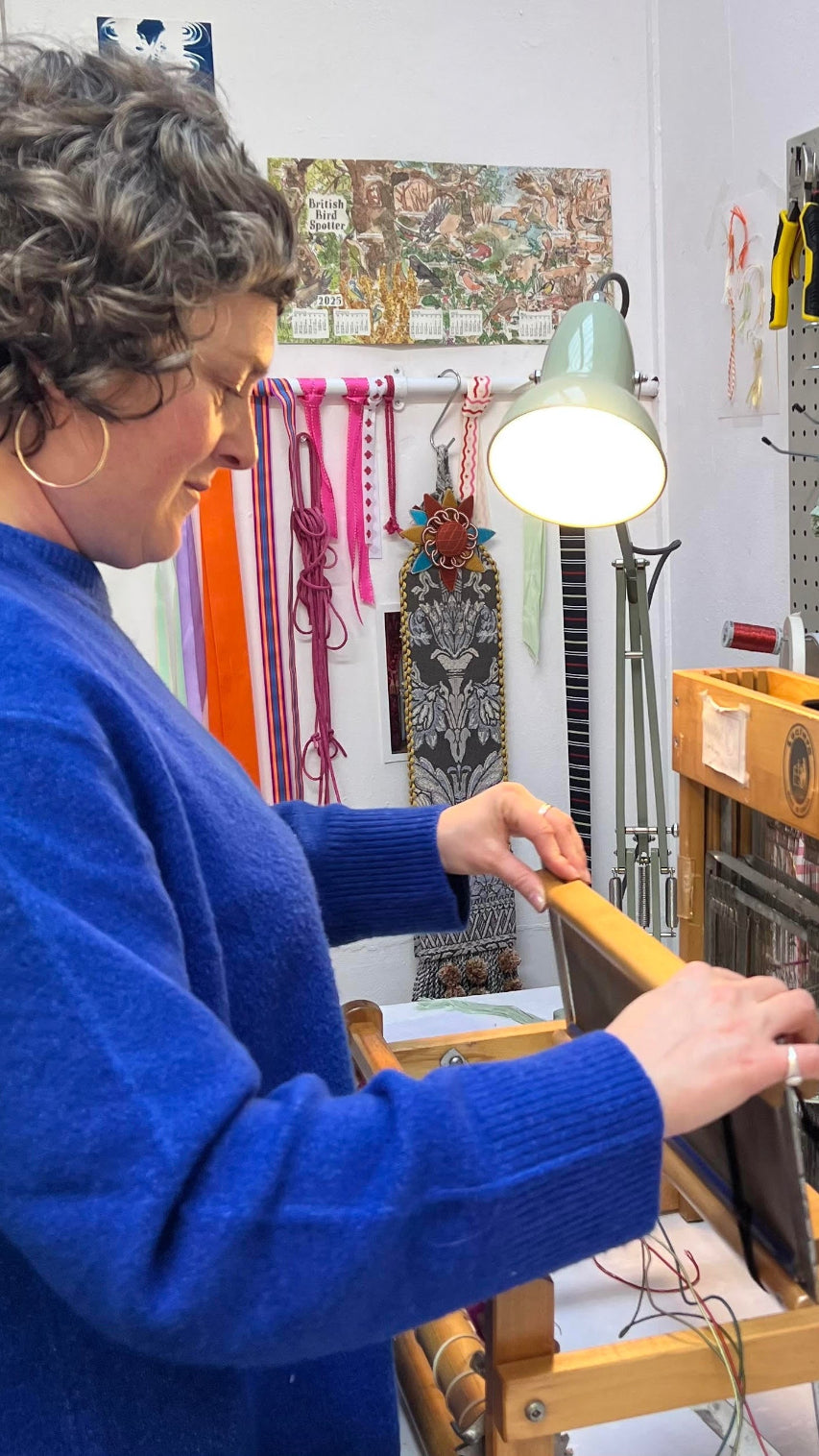 Person working with a loom in a workshop setting
